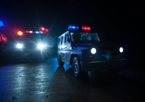 Police cars at night. Police car chasing a car at night with fog background. 911 Emergency response police car speeding to scene of crime. Selective focus